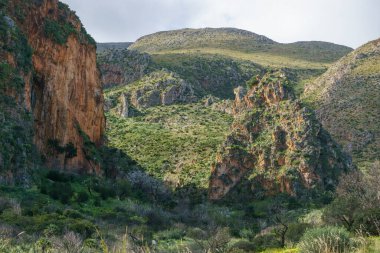 Akdeniz, San Vito Lo Capo, Sicilya, İtalya 'daki Zingaro Doğa Rezervi' nde kaya oluşumları ile dağ manzarası