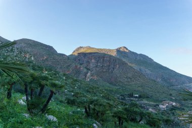 Akdeniz, San Vito Lo Capo, Sicilya, İtalya 'daki Zingaro Doğa Rezervi' nde kaya oluşumları ile dağ manzarası