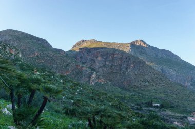 Akdeniz, San Vito Lo Capo, Sicilya, İtalya 'daki Zingaro Doğa Rezervi' nde kaya oluşumları ile dağ manzarası