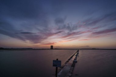 Gün batımından sonra akşam saatlerinde canlı gökyüzü tuz tarlalarıyla Saline di Trapani ve Torre Nubia, Contrada Nubia, Sicilya, İtalya