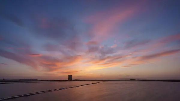 stock image Vibrant sky during evening twilight after sunset at nature reserve Saline di Trapani with salt fields and Torre Nubia, Contrada Nubia, Sicily, Italy