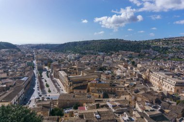 Güneşli bir bahar gününde, dağlarda küçük bir kasabanın manzarası, Scicli, Sicilya, İtalya