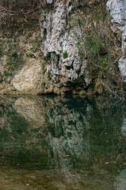 Pantalica, Siracusa, Sicilya, İtalya 'nın doğal koruma alanındaki nehirdeki tuhaf kaya oluşumunun yansımasıyla Anapo Vadisi' nin manzarası.