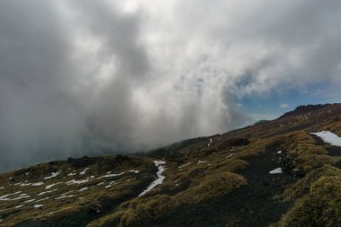 Volkanik Etna Dağı manzarası kara lav ve sarı otlarla bulutlu bir kış gününde, Catania, Sicilya, İtalya