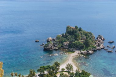 Sicilya, İtalya 'da güneşli bir günde, Akdeniz kıyısında berrak turkuaz suyla Taormina' daki Isola Bella adasına bakın.