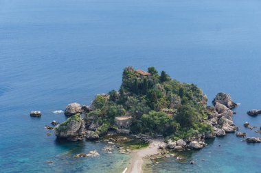 Sicilya, İtalya 'da güneşli bir günde, Akdeniz kıyısında berrak turkuaz suyla Taormina' daki Isola Bella adasına bakın.