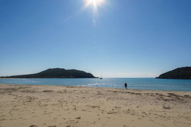 Tourist on empty Ammoudia beach on a sunny spring day, Ammoudia, Epirus, Greece clipart