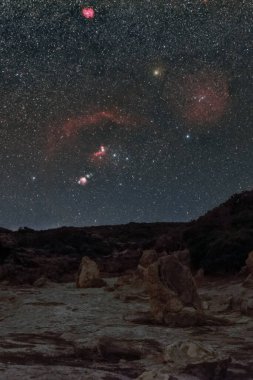 Petrified tree trunks at Geopark of Agios Nikolaos Petrified Forest with Orion constellation and nebula at the night sky, Laconia, Peloponnese, Greece clipart