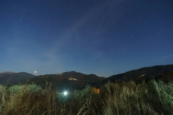 Yunan kırsal kesiminin gece manzarası Figaleia köyü yakınlarındaki ay ışığı ve yukarıdaki yıldızlar, Phigalia, Moreloponese, Yunanistan