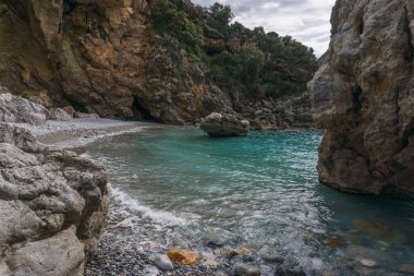 Famous rocky beach Foneas near Kardamyli village with turquoise colored water in spring time, Messinia, Peloponnese, Greece clipart