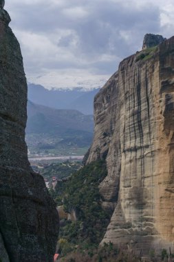 Meteora kaya oluşumunun geçidine bakın. Uzakta karlı dağlar, Kalambaka, Teselya, Yunanistan.