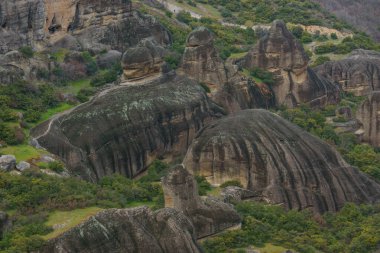 Meteora kaya oluşumlarının aşınmış kayaları ile bahar zamanı yeşil çimenli manzaranın ayrıntıları, Kalambaka, Teselya, Yunanistan