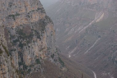 Pindus Dağları 'ndaki Zagoria bölgesindeki Vikos geçidine bakın. Karanlık, sisli bir kış günü, atmosferik havayla, Epirus, Yunanistan