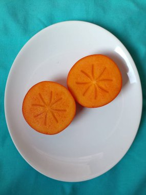 Beyaz tabakta taze olgun hurma.