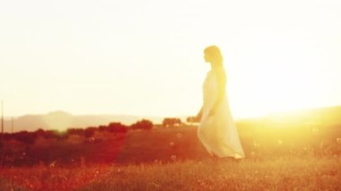 Kız gün batımında kırsalda yalınayak yürüyor..