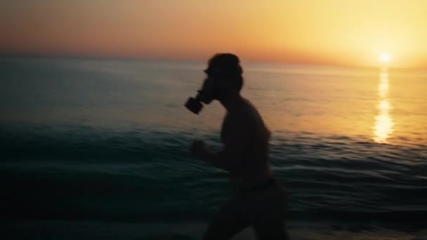 Muž Vlaky Při Východu Slunce Pláži Plynovou Maskou — Stock video