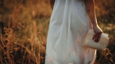 Gün batımında kitap okuyan bir kadın. 