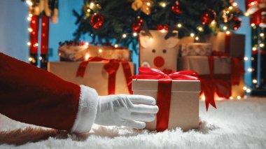 Noel Baba 'nın elini Noel hediyesi kutusuyla kapat.