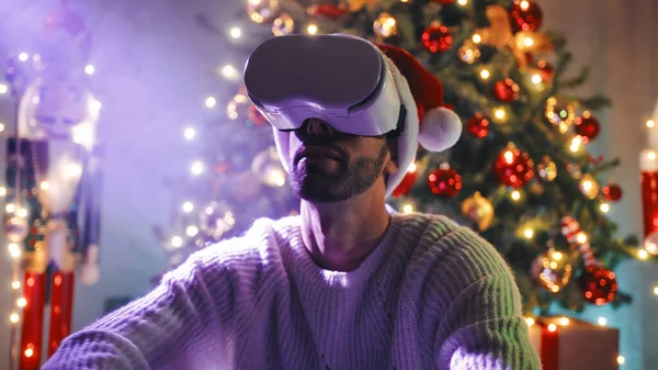 男はクリスマスツリーの下で仮想現実と遊ぶ — ストック写真