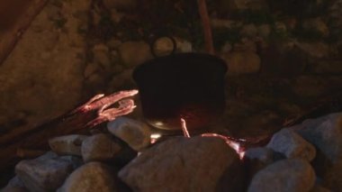 Close up of a black pot on campfire 