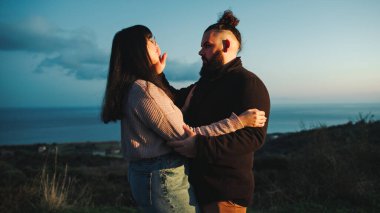 Close up of engaged couple embrace at blue hour