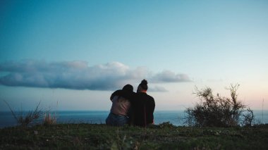 engaged couple looks towards the horizon.