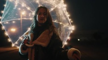 Happy girl with transparent umbrella with fairy lights