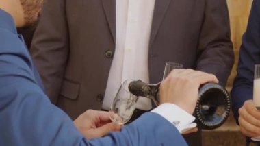 married pours sparkling wine into the goblet.