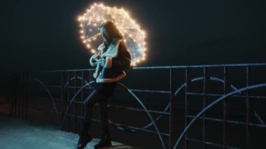 Happy girl with transparent umbrella with fairy lights