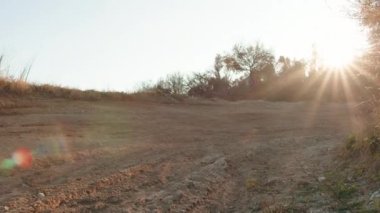 Motorcunun yavaş hareketi toprak yolda sıçrıyor.