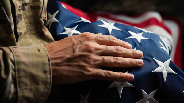 USA soldier caressing a United states flag on veterans day.