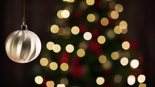 Gouden Bal Decoratie Met Wazige Kerstboom — Stockvideo