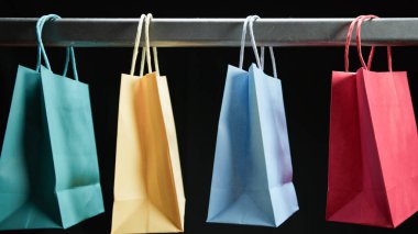 Alışveriş torbaları siyah arka planda asılı..