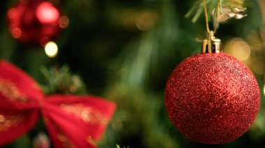 Kırmızı top Noel ağacını süslüyor..