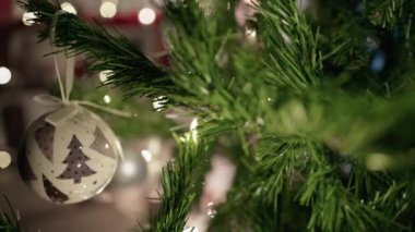 Beyaz balo ve ışıklar Noel ağacını süslüyor .
