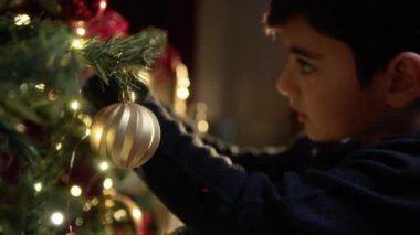 Çocuk Noel ağacını süsleyip hazırlıyor. . 