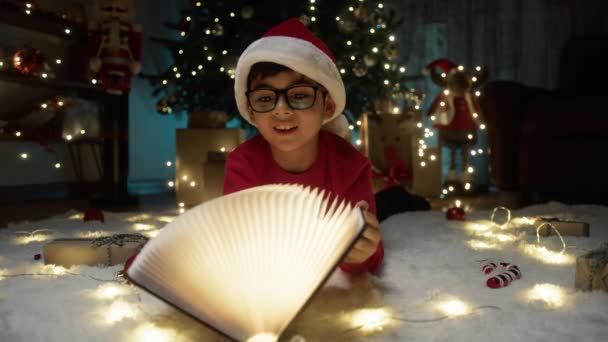 Niño Sorprendido Por Libro Magia Bajo Árbol Navidad — Vídeos de Stock