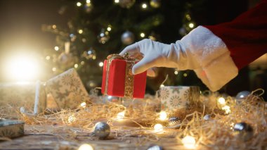 Noel Baba ağacın altına hediye bırakıyor.