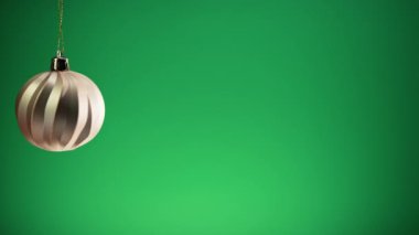 Yeşil arka planlı Noel için altın top süslemesi . 