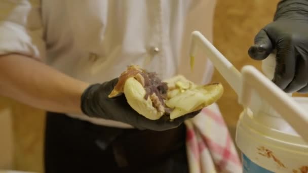 Menuangkan Mustard Pada Sandwich Dengan Daging Babi — Stok Video