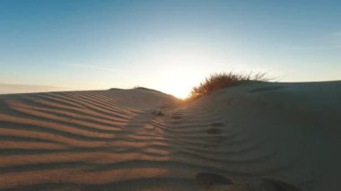 Gün batımında kumlu kumulların üzerinde uçmak 