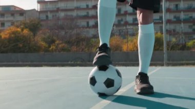 Futbolcu topu ayağının altında tutuyor. . 