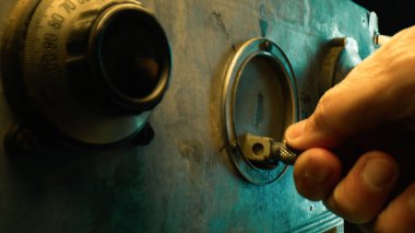 Para çalmak için kasanın çarkını açmak..