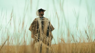 Pançolu adam toprak yolda yürüyor.