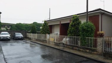 Yağmurlu bir günde evin önüne park edilen arabalar. .