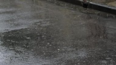 Asfalttaki su birikintisine düşen yağmur damlaları.