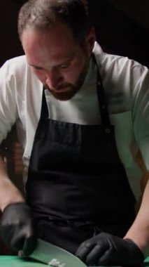 Şef bir mürekkepbalığını dilimlemek için bıçak kullanıyor. .