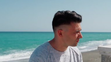 Denizin kenarında oturan bir adam bekliyor. . 