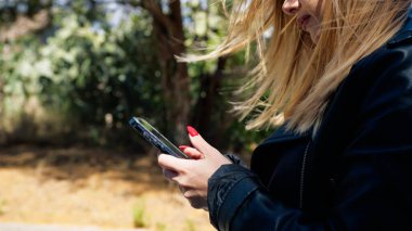 Parkta Yürüyen Akıllı Telefonunu Kullanan Kadın . 