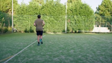 Tenis oyuncusu mahkemede raketle koşuyor. .
